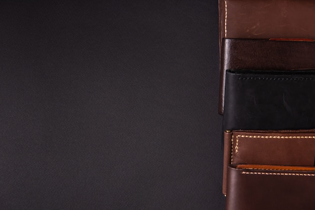 leather wallets on a black background with space for an inscription. Leather craft concept.