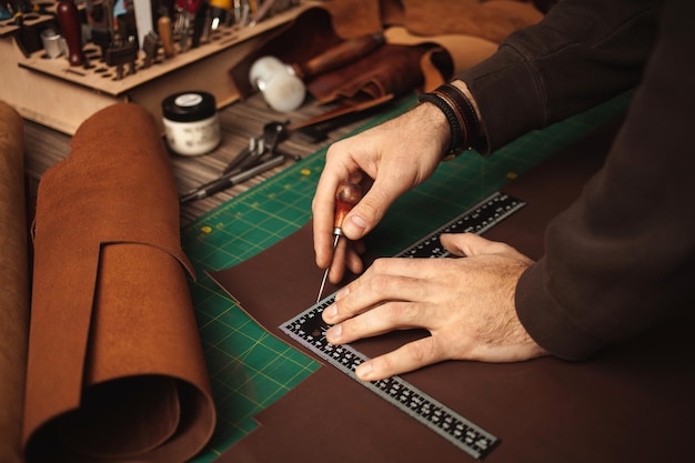 Leatherworker draws measures with ruler tanner works with leather small business production