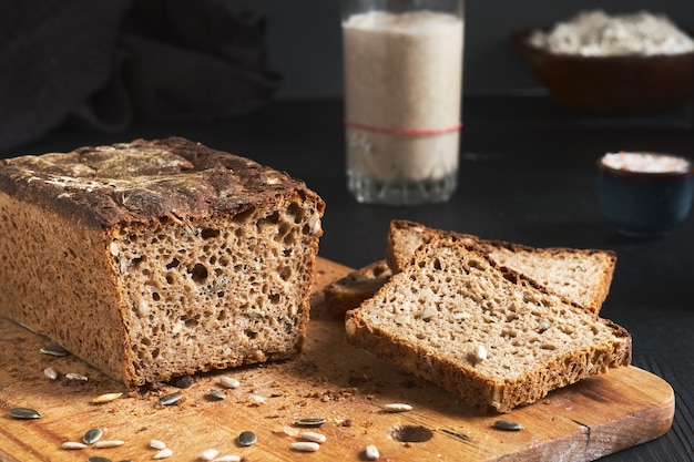 Pane lievitato, pane integrale di segale con zucca e semi di girasole. antipasto di lievito in tavola. autentico prodotto biologico di pane fatto in casa a lievitazione naturale. prodotto artigianale, fette di pane a bordo