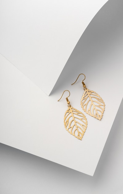 Photo leaves shape earrings pair on white folded paper