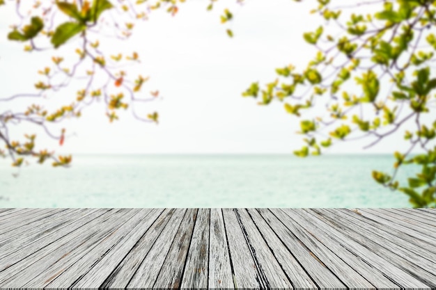 Leaves with wooden on sea blank table on blue water shore and blue sky at coast sunlight blur bokeh on ocean mockup tropical seaside Tourism relax vacation travel summer holidays