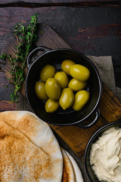 Lebanese bread pita bread and olives set on old dark wooden table background top view flat lay with copy space for text