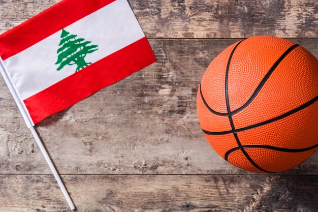 Lebanese flag and basketball on wooden table