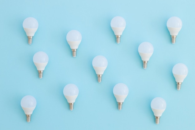 LED light bulb lies on a pastel blue background Energy saving concept Minimalism top view