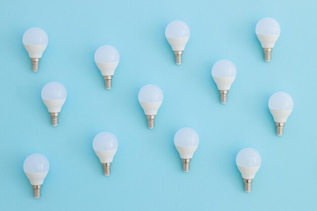 LED light bulb lies on a pastel blue background Energy saving concept Minimalism top view