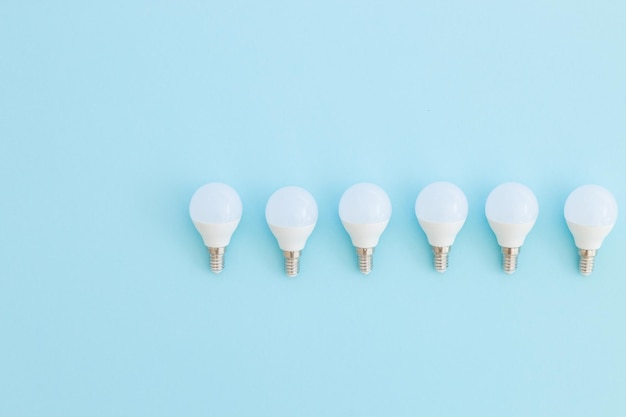 LED light bulb lies on a pastel blue background Energy saving concept Minimalism top view