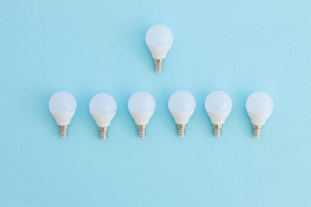 LED light bulb lies on a pastel blue background Energy saving concept Minimalism top view