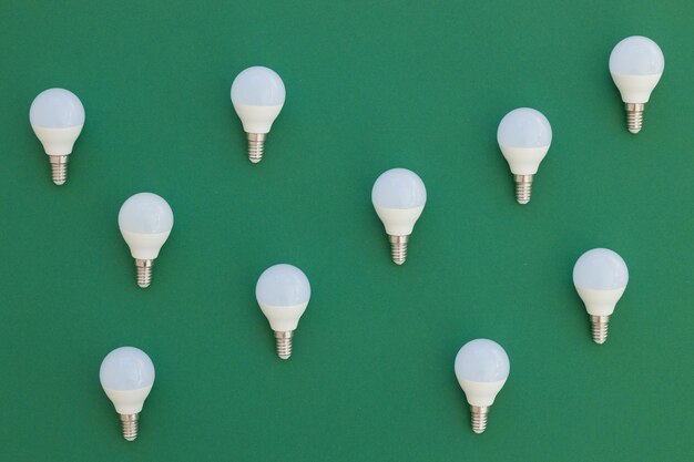 LED light bulb lies on a pastel green background Energy saving concept Minimalism top view