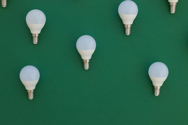 LED light bulb lies on a pastel green background Energy saving concept Minimalism top view