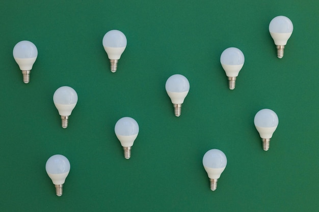 LED light bulb lies on a pastel green background Energy saving concept Minimalism top view