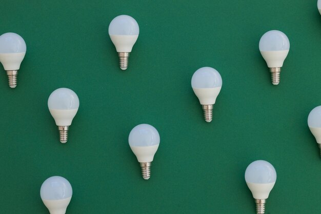 LED light bulb lies on a pastel green background Energy saving concept Minimalism top view