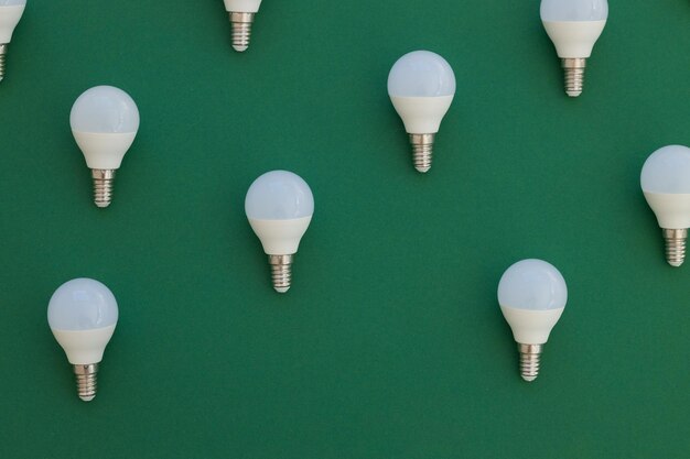 LED light bulb lies on a pastel green background Energy saving concept Minimalism top view