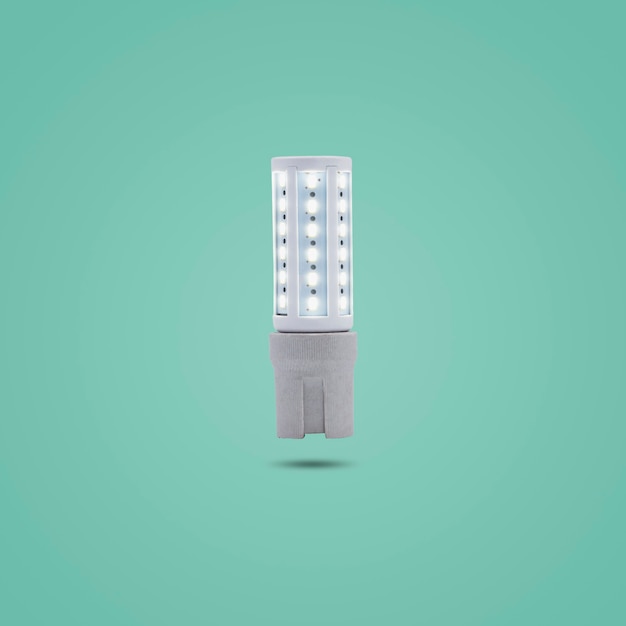 LED spaarlamp 230v in een keramische socket geïsoleerd op groene pastelkleurige achtergrond.
