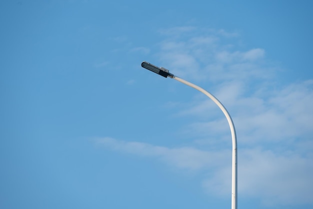 青い空の下でLED街路灯が点灯