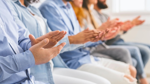 Leden van de therapiesessie zitten in een rij en applaudisseren de spreker