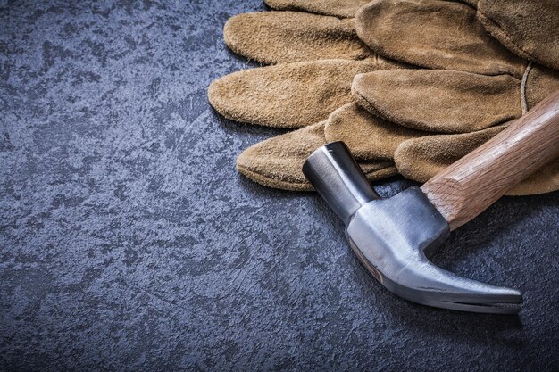 Lederen bruine beschermende handschoenen metalen klauwhamer bouwconcept