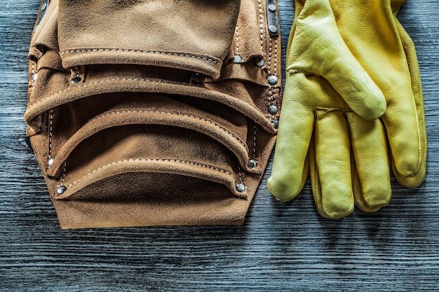 Lederen constructie riem beschermende handschoenen op houten bord.