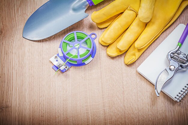 Lederen handschoenen snoeischaar zachte twist stropdas hand spade schrift op houten plank tuinieren concept