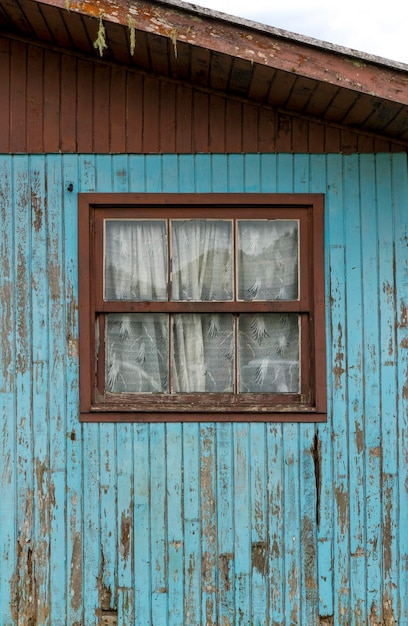 Leeftijd rustieke houten achtergrondstructuur in blauw met ouder venster.