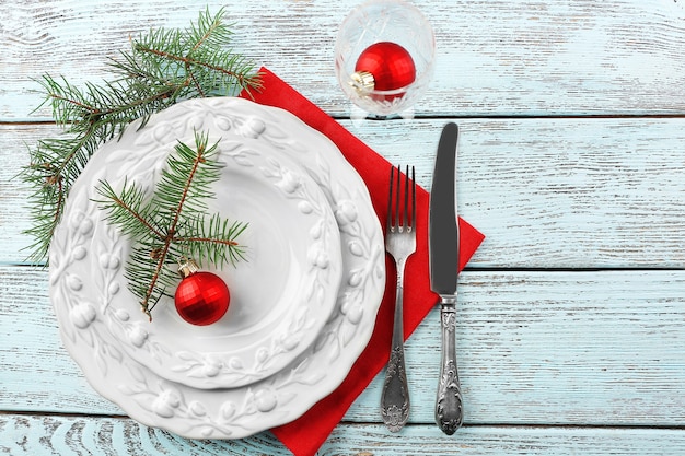 Leeg bord, bestek, servet en glas op rustieke houten ondergrond. Kerst tafel setting concept