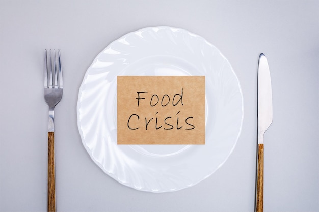 Leeg bord met poster van voedselcrisis Stijgende voedselkosten
