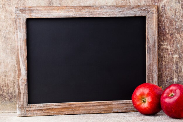 Leeg bord met rode appels over houten tafel.