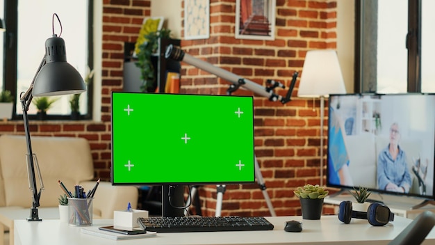 Leeg bureau met greenscreen-sjabloon op monitor, geïsoleerde mockupachtergrond die op computer draait. Desktop-pc met lege kopieerruimte op chroma key-display, mock-up groen scherm.