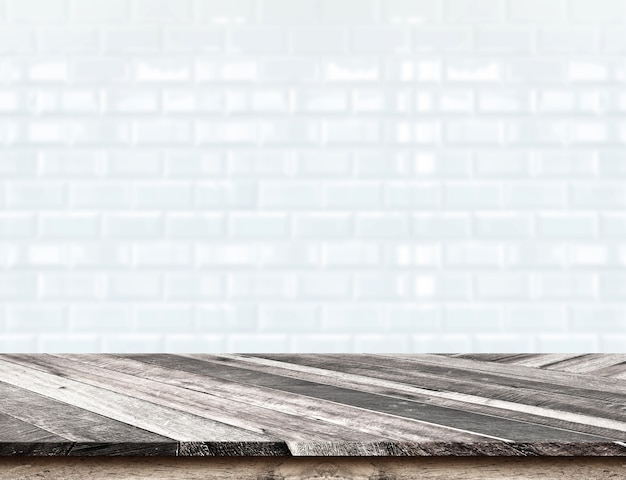 Leeg diagonaal houten tafelblad bij vage witte tegels keramische muur, sjabloon mock voor weergave van uw product, bedrijfspresentatie