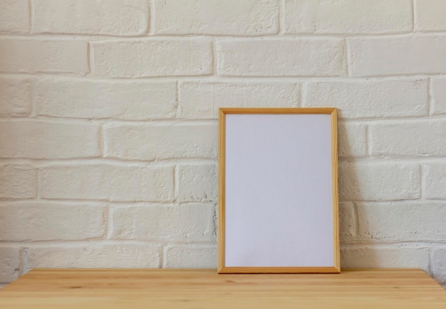 Leeg fotolijstje in een houten frame op een houten tafel met kopieerruimte