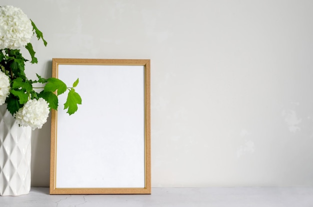 Leeg frame en boeket van witte bloem hortensia in een vaas op grijze achtergrond