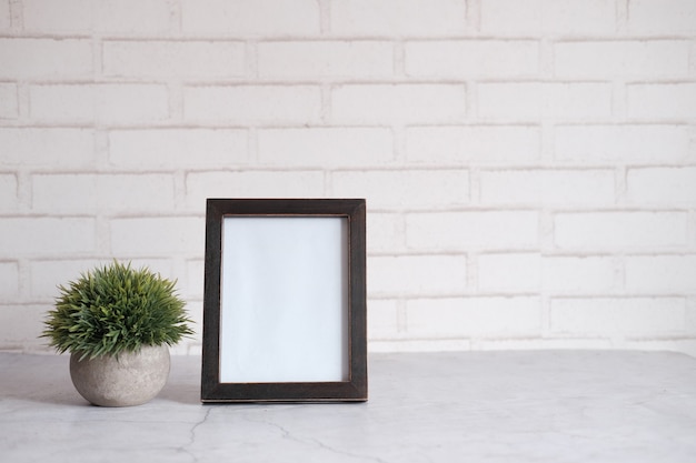 leeg frame op tafel tegen witte muur