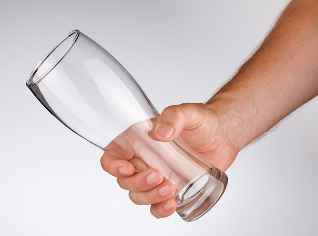 Leeg glas in zijn hand op een witte achtergrond