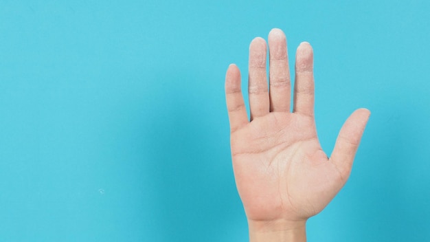 Foto leeg handpalm met babypoeder op blauwe achtergrond