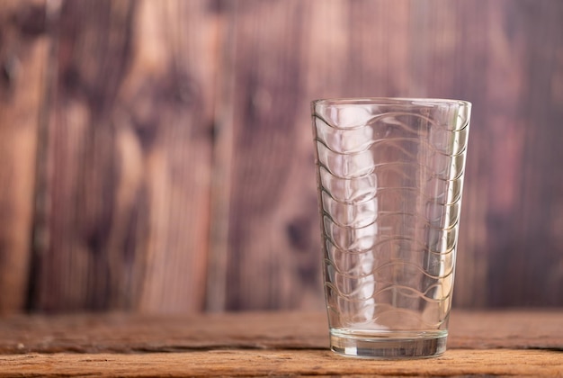 Foto leeg helder glas water op de houten tafel met een wazige achtergrond