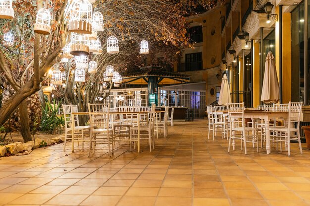 Leeg hotelterras 's nachts met verlichte lantaarns in de bomen