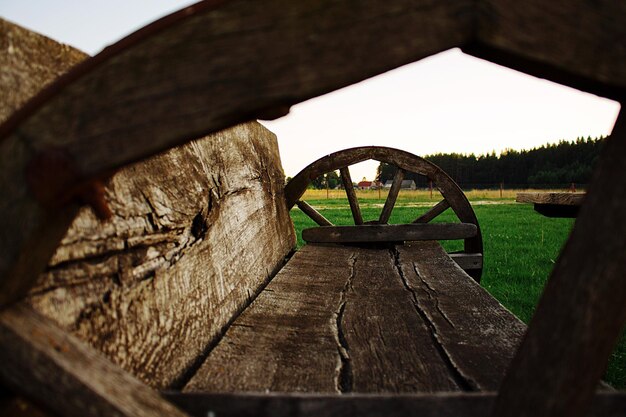 Foto leeg houten bank op het veld tegen de lucht