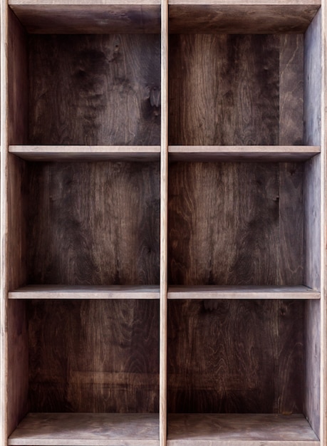 Leeg houten boekenrek op een muur