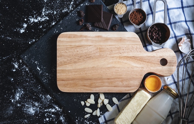 Leeg houten dienblad met bakkerij en zoete voedselingrediënten