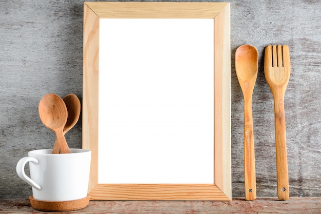 Leeg houten frame en keukengerei op een houten lijst