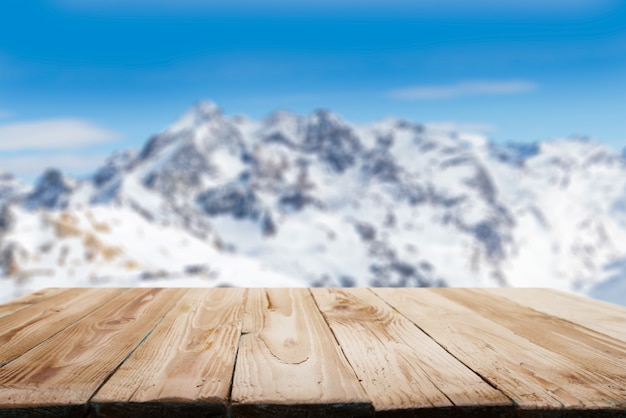 Leeg houten oppervlak tegen besneeuwd bergachtig gebied op winterdag