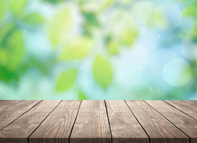 Leeg houten tafelblad en wazig van binnenkamer met raam uitzicht vanaf groene boomtuin achtergrond