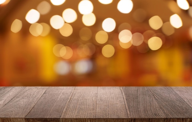 Leeg houten tafelplaat en vervaging van de achtergrond van het restaurant selectieve focus productdisplay
