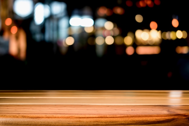 Leeg houten tafelplatform en bokeh's nachts