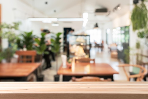 Foto leeg houten tafelruimteplatform en wazig onscherp restaurantinterieur en coffeeshop