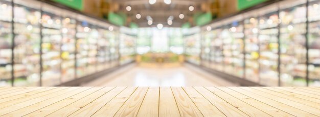 Foto leeg houten tafeltop met supermarkt kruidenierswinkel gangpad en planken onduidelijke achtergrond