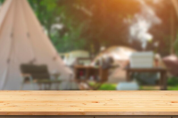 Leeg houten tafeltop op een wazige achtergrond van kampeertenten in het kampeerterrein in het natuurpark
