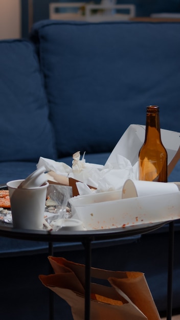 Leeg huis van depressieve persoon met rommelige tafel met restjes op de vloer gegooid in ongeorganiseerd leven ...