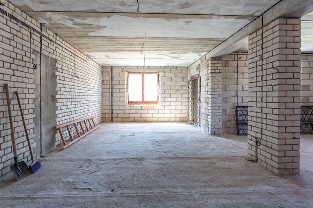 Leeg interieur in huis zonder reparatie met witte silicaatbakstenen muren