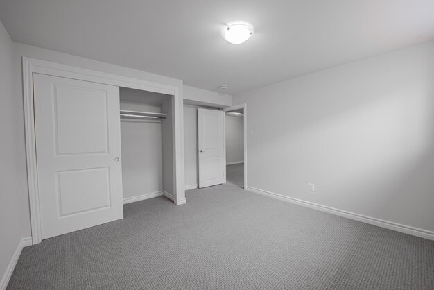Foto leeg, niet gemeubileerde kelderkamer van een huis met witte muren en een tapijtvloer