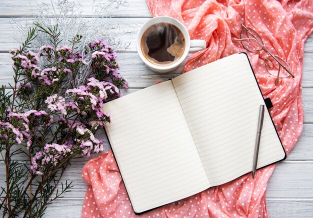 Leeg open notitieboekje met bloemen en koffiekop, hoogste mening